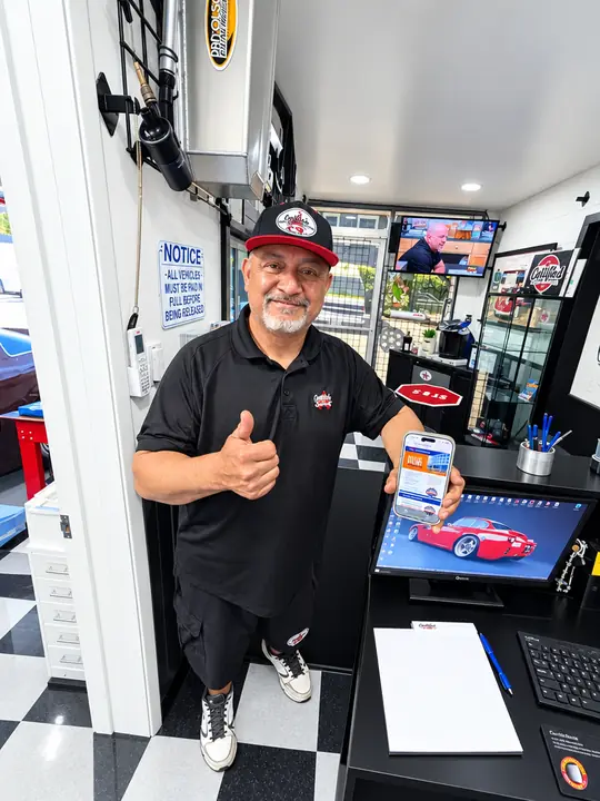 Rafael Cedillo welcoming customers with a thumbs-up at Cedillo's Classic & Auto Repair in Fullerton